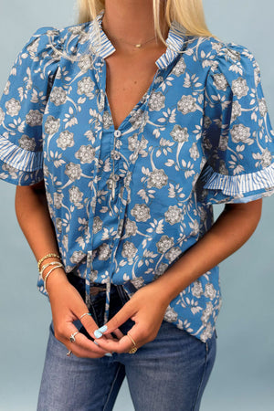 Blusa manga corta con detalle de rayas y cuello con botones y estampado floral azul