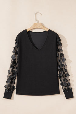Blusa manga larga con cuello en V y malla con apliques de flores negra