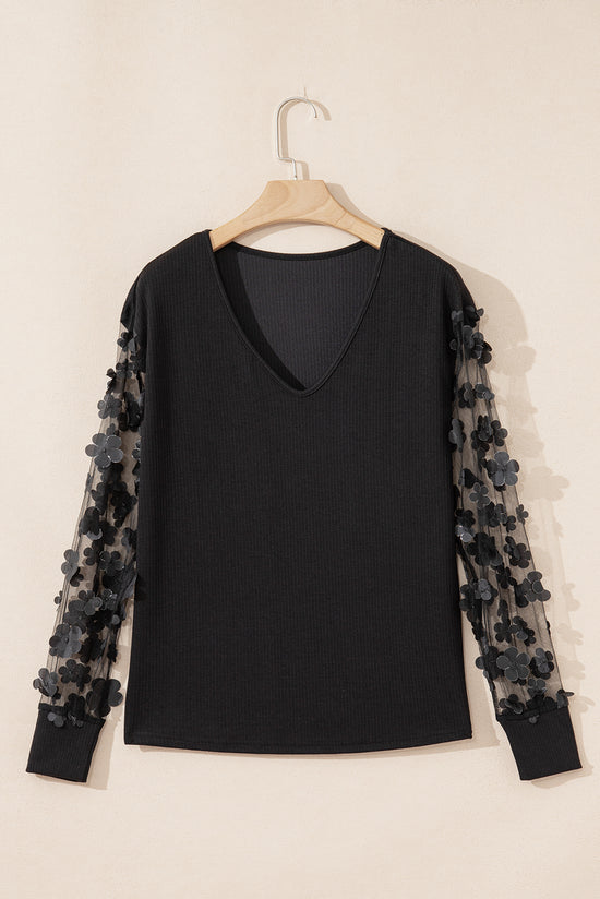 Blusa manga larga con cuello en V y malla con apliques de flores negra