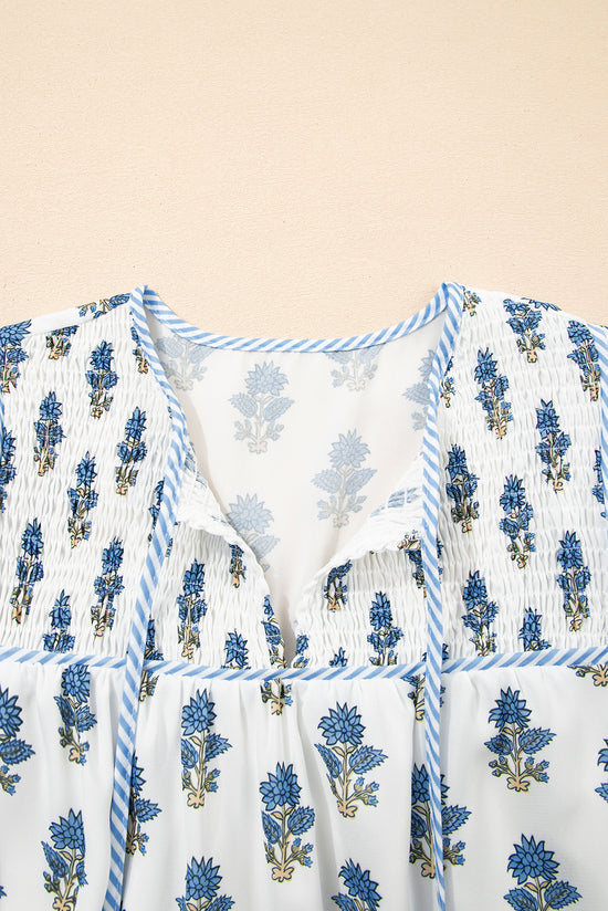Mini vestido floral azul celeste com manga bufante amarrada no pescoço e bolso