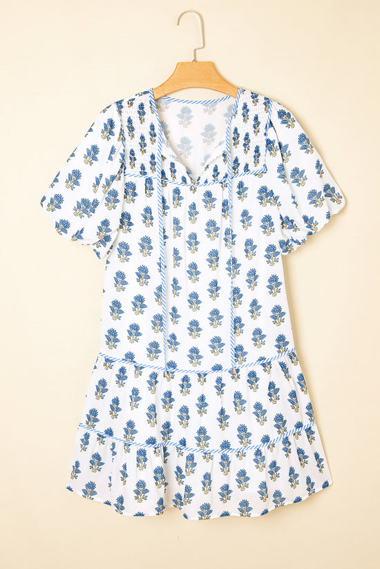 Mini vestido floral azul celeste com manga bufante amarrada no pescoço e bolso