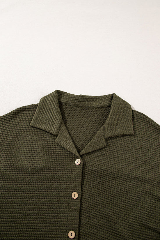Camisa abotonada con textura de color sólido negro y pantalones casuales