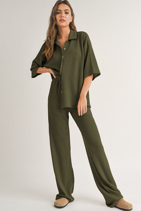 Camisa abotonada con textura de color sólido negro y pantalones casuales