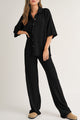 Camisa abotonada con textura de color sólido negro y pantalones casuales
