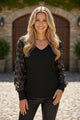 Blusa manga larga con cuello en V y malla con apliques de flores negra