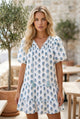 Mini vestido floral azul celeste com manga bufante amarrada no pescoço e bolso