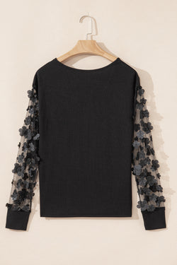 Blusa manga larga con cuello en V y malla con apliques de flores negra