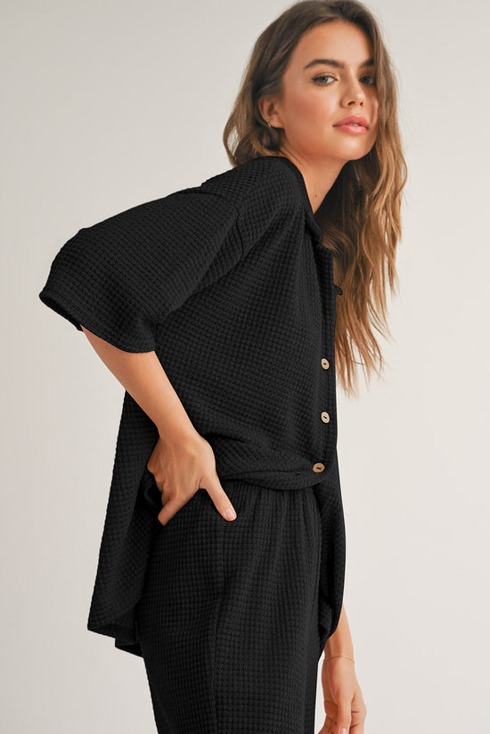 Camisa abotonada con textura de color sólido negro y pantalones casuales
